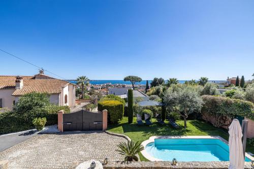 une cour arrière avec une piscine et une maison dans l'établissement Villa Flore - Panoramic Sea View by Halldis, à Vallauris