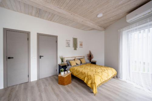 a bedroom with a bed with a yellow blanket at Sea Bees vacation homes in Ragaciems