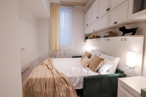 a white bedroom with a bed and a green couch at Brand New! Valletta Boutique Style Apartment in Valletta