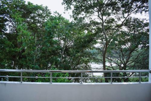 a view of a fence with trees in the background at Hotel Sobana Lake front in Udawalawe