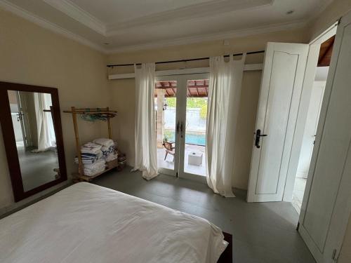 a bedroom with a bed and a large window at Balieys Villa, Tranquil Hideaway in Central Canggu in Canggu