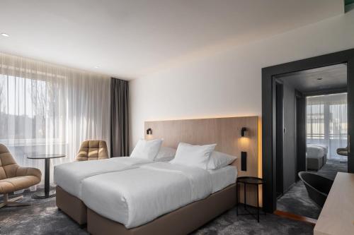 1 dormitorio con 1 cama blanca grande y ventana grande en OREA Congress Hotel Brno, en Brno