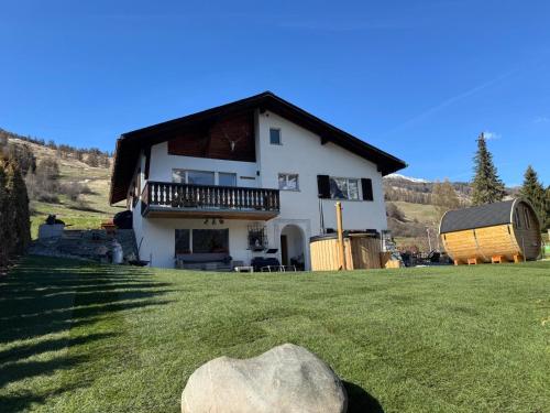 a large white house with a balcony and a yard at Berg-Bijou Scuol in Scuol
