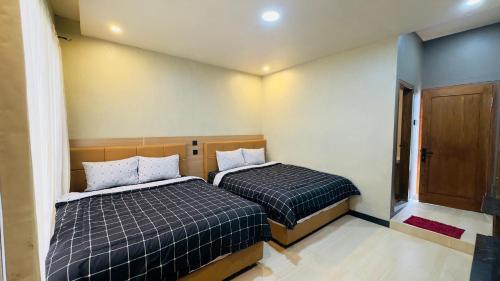 two beds in a small room with at Sky View Bromo Guest House in Ngadisari