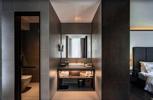 a bathroom with a sink and a toilet and a bed at Shangyin Chuanbu Holiday Manor in Huzhou