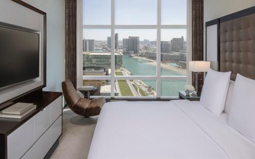 a hotel room with a large bed and a large window at Rosewood Abu Dhabi in Abu Dhabi
