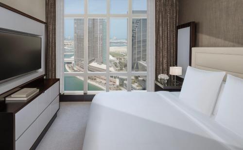 a hotel room with a large bed and a large window at Rosewood Abu Dhabi in Abu Dhabi