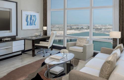a living room with a tv and a couch and a table at Rosewood Abu Dhabi in Abu Dhabi