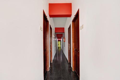 an empty hallway with red walls and a long corridor at Hotel O East Fort in Trivandrum