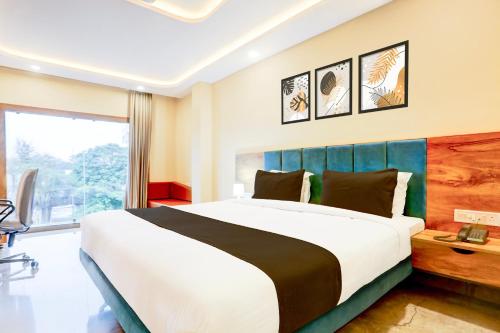 a bedroom with a large bed and a large window at Super Townhouse Oak Dhanbad Near SSLNT College formerly Kapson in Dhanbād