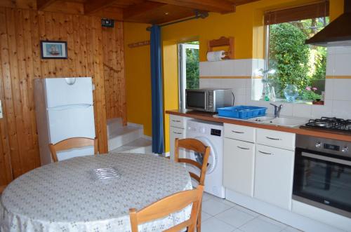 La cuisine est équipée d'une table, d'un évier et d'un four micro-ondes. dans l'établissement Petit gîte tranquille, à Arradon