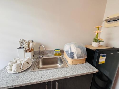 Una encimera de cocina con fregadero y microondas. en Zebs cozy cove, en Cebú