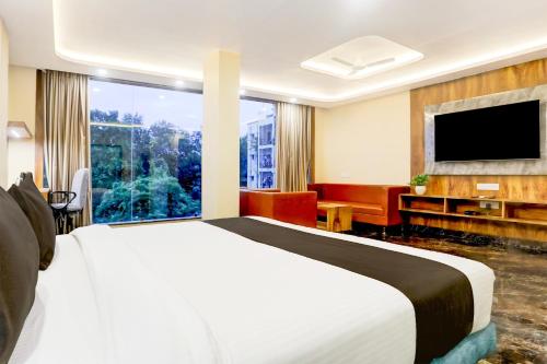 a hotel room with a bed and a large window at Super Townhouse Oak Dhanbad Near SSLNT College formerly Kapson in Dhanbād