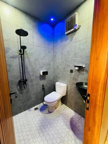 a bathroom with a toilet and a shower and a sink at Sky View Bromo Guest House in Ngadisari