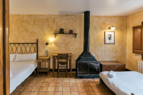 a room with a stove and a bed and a desk at Habitacions Mas Fuselles in Girona