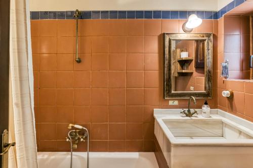 a bathroom with a tub and a sink and a mirror at Habitacions Mas Fuselles in Girona