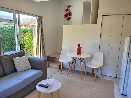 a living room with a couch and a table and chairs at Private Self Contained Unit in Claudelands