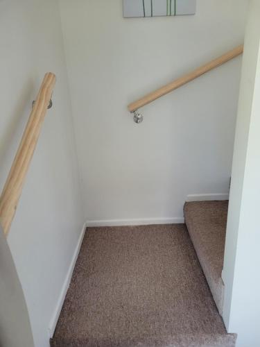 a room with a stairway with a wooden rail at Private Self Contained Unit in Claudelands