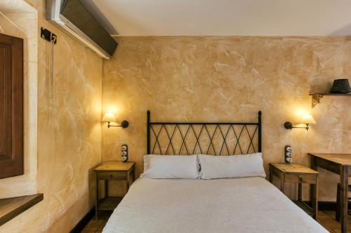 a bedroom with a bed with two night stands and two tables at Habitacions Mas Fuselles in Girona