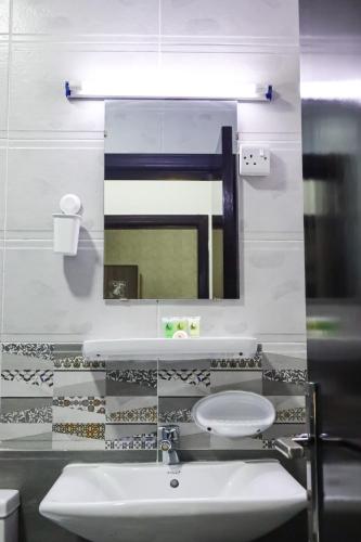 a bathroom with a sink and a mirror at AL MARSA HOTEL APARTMENTS in Khor Fakkan