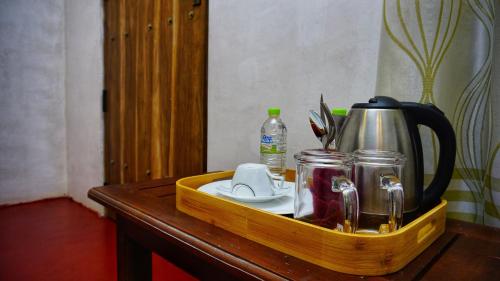 a wooden tray on a table with a tea kettle at Lake Island Home Stay in Dambulla