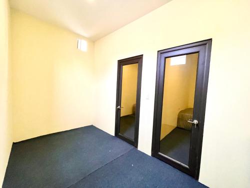 an empty room with two doors and a toilet at Lee's House in Dong Anh