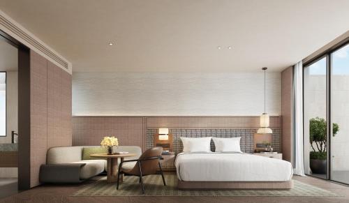 ein Schlafzimmer mit einem Bett, einer Couch und einem Tisch in der Unterkunft Holiday Inn Resort Ningbo Ninghai by IHG in Ninghai