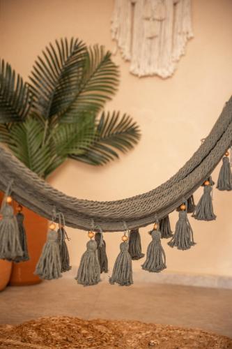 a shelf with tassels on a wall with a plant at Hotel El Mirador in Puerto Escondido