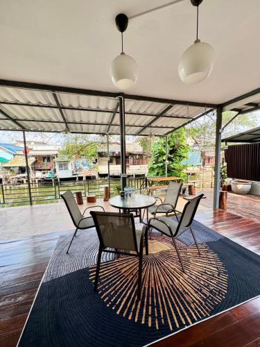 a patio with a table and chairs on a rug at DD Canel in Bangkok