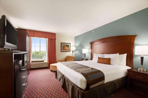 a hotel room with a bed and a television at Wingate by Wyndham San Marcos in San Marcos