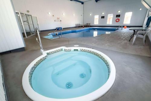 a large bath tub in a room with a swimming pool at Super 8 by Wyndham Medicine Hat AB in Medicine Hat