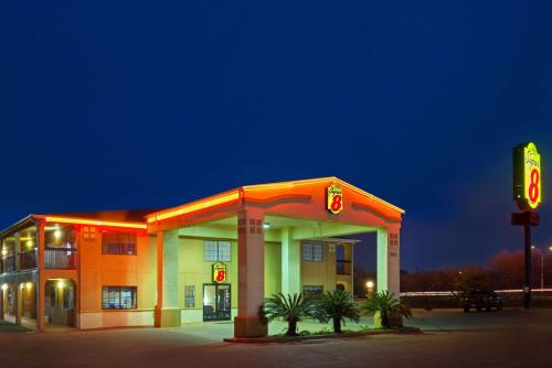 a hotel with a gas station at night at Super 8 by Wyndham San Antonio/Riverwalk Area in San Antonio