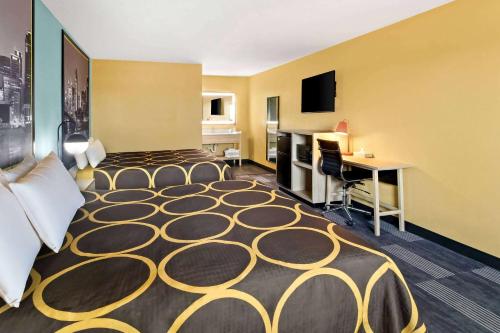 a hotel room with a bed and a desk at Super 8 by Wyndham Vandalia/Dayton International Airport in Vandalia
