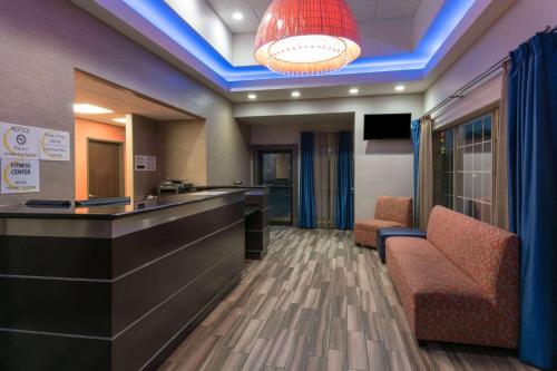 a lobby with a bar and chairs and a light at Super 8 by Wyndham San Antonio Near Fort Sam Houston in San Antonio
