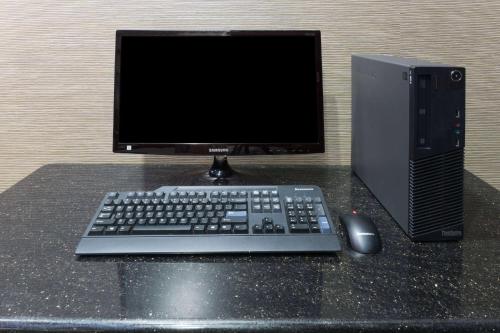 a computer monitor and a keyboard and mouse on a table at Super 8 by Wyndham San Antonio Near Fort Sam Houston in San Antonio
