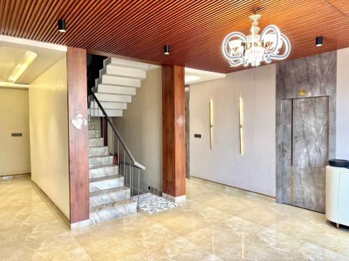 a staircase in a building with a chandelier at Krishna Residency A Boutique Hotel in Bareilly