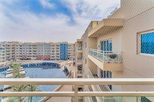 a balcony with a view of a pool and buildings at Smart Home with Alexa Near Yas and Airport with Pool in Abu Dhabi