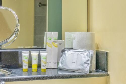 a bathroom counter with toiletries and a mirror at Smart Home with Alexa Near Yas and Airport with Pool in Abu Dhabi