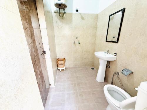 a bathroom with a sink and a toilet and a mirror at Krishna Residency A Boutique Hotel in Bareilly