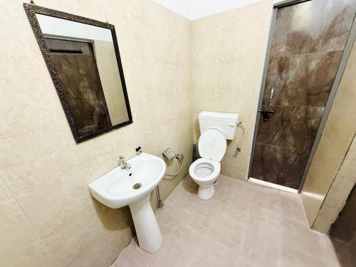 a bathroom with a toilet and a sink and a shower at Krishna Residency A Boutique Hotel in Bareilly