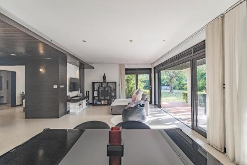 a living room with a bed and sliding glass doors at Le Oasis - 3BR Beachfront HOME in Laguna & Layan Beach next KORA Resort in Phuket
