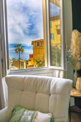 a couch sitting in front of a window with a view at Les Logettes 2 in Menton