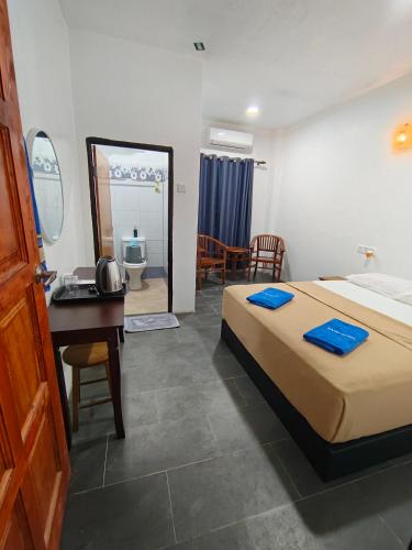 a hotel room with a bed and a desk and a bedroom at Perhentian Najmi Hotel in Perhentian Island