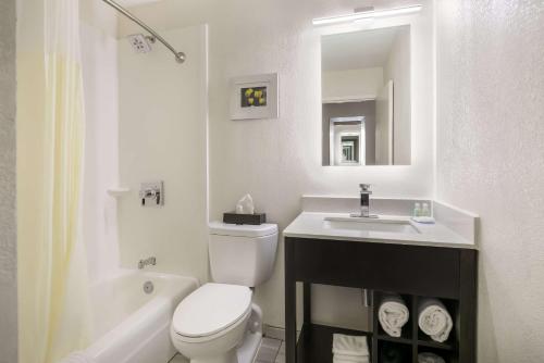 a white bathroom with a toilet and a sink at Clarion Hotel Conference Center in Maggie Valley
