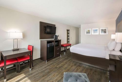 a hotel room with a bed and a desk and a television at Clarion Hotel Conference Center in Maggie Valley
