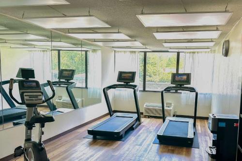 a gym with three treadmill machines in a room at Clarion Hotel Conference Center in Maggie Valley