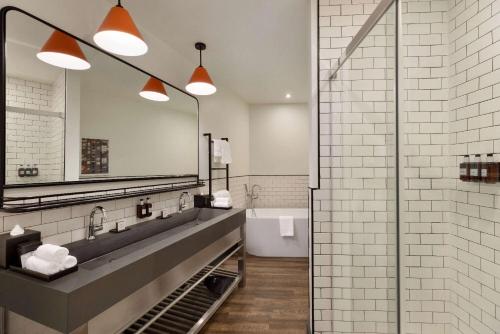 a bathroom with a sink and a mirror at Origin Westminster a Wyndham Hotel in Westminster