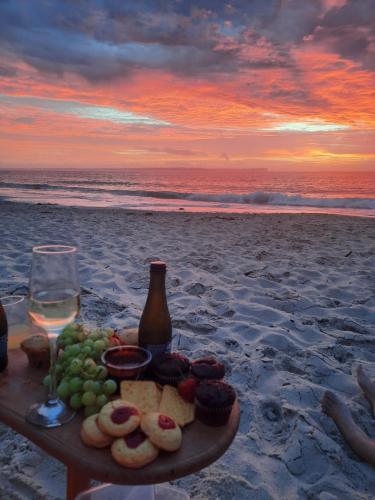 a tray of food and wine on the beach at Stay Breezy in Erowal Bay