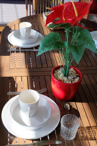 a table with plates and cups and a plant on it at Old Lighthouse - Beach Apartment - Fiumicino Airport in Fiumicino