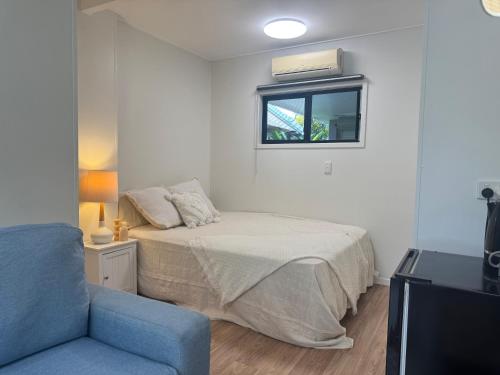 a bedroom with a bed and a window and a couch at Haven39 in Bayview Heights